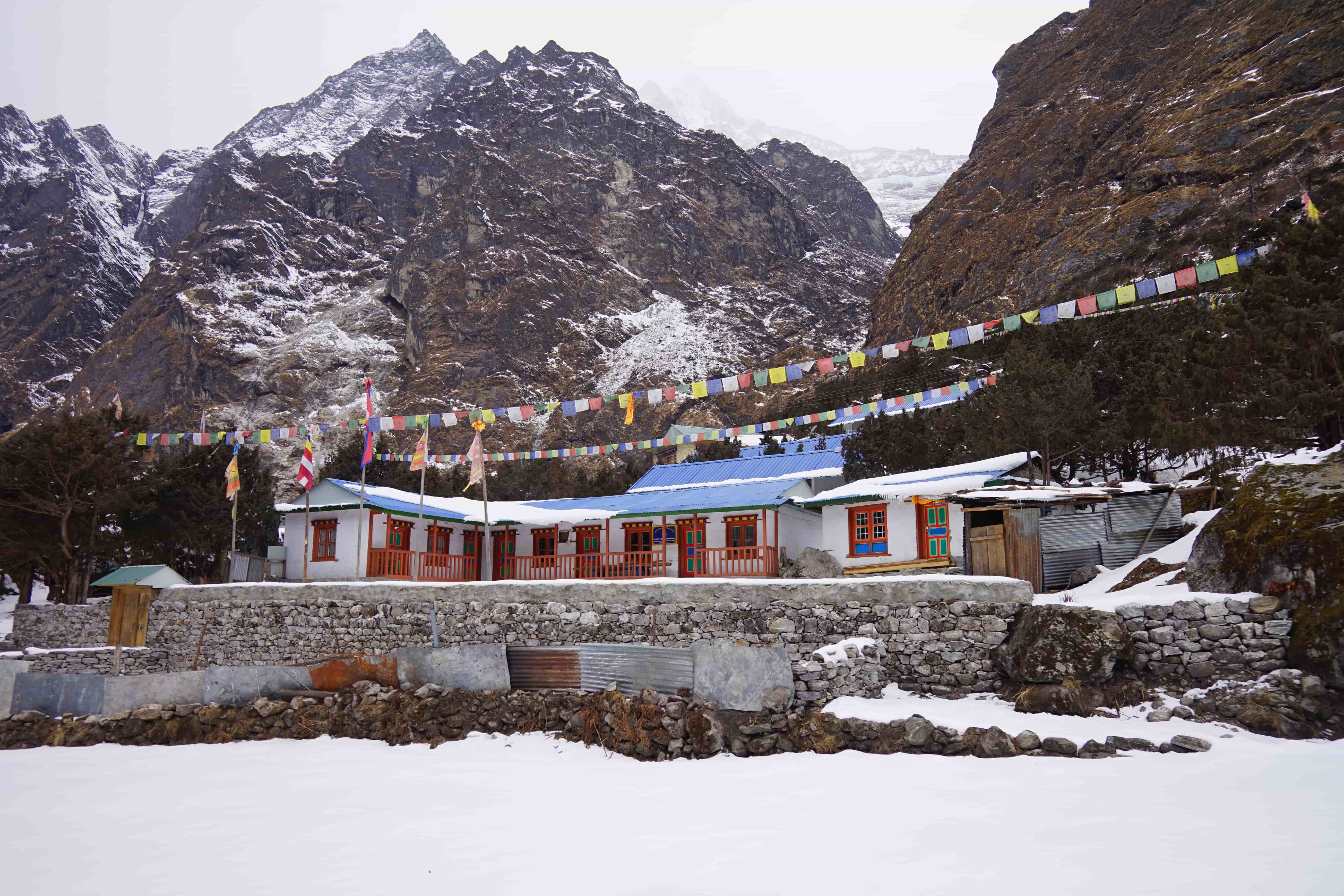 Trekkers crossing snowy trail in Rolwaling Himal, Nepal.