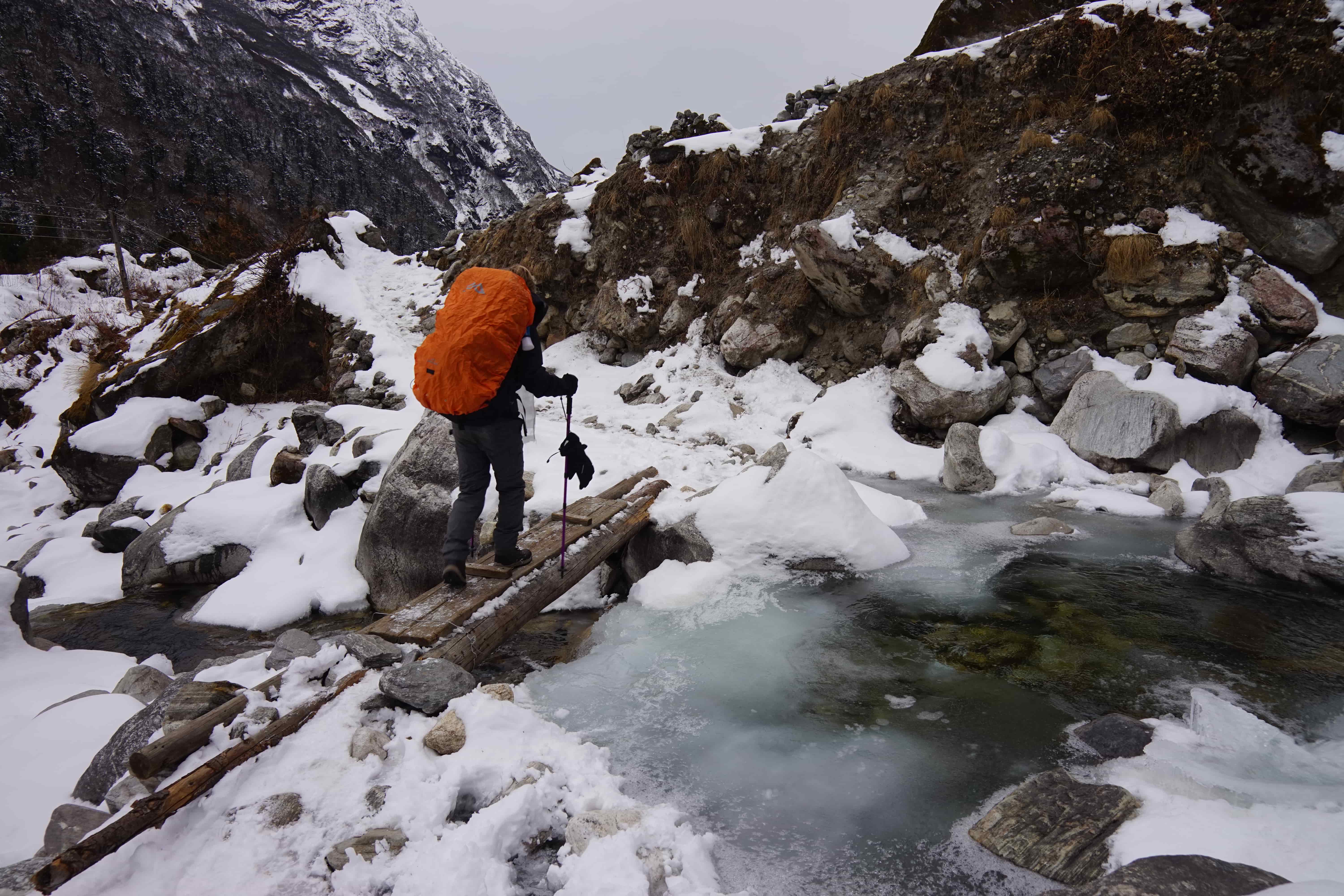 Trekkers crossing snowy trail in Rolwaling Himal, Nepal.